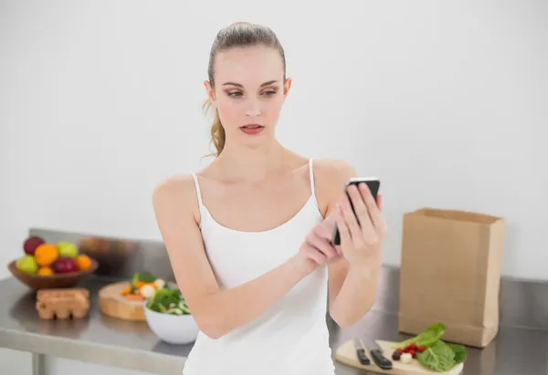 Mujer joven y seria enviando un mensaje — Foto de Stock