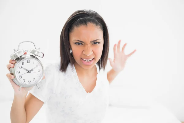 Furious young model throwing an alarm clock — Stock Photo, Image