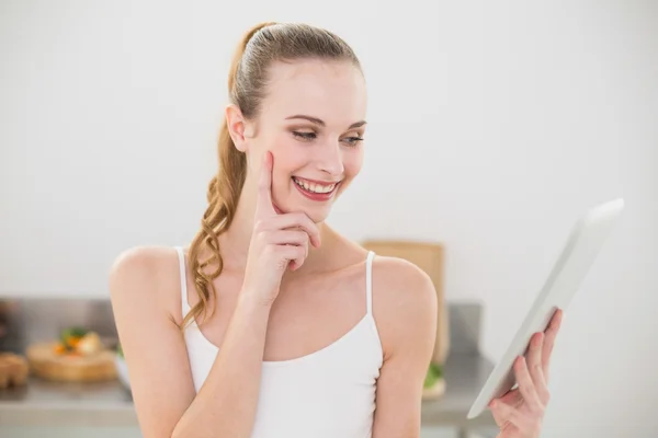 Fröhliche junge Frau mit ihrem Tablet-PC — Stockfoto