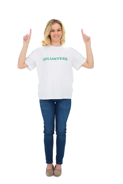 Smiling blonde volunteer pointing up — Stock Photo, Image