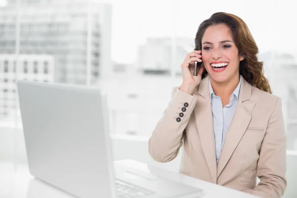 Mulher de negócios rindo no telefone em sua mesa — Fotografia de Stock