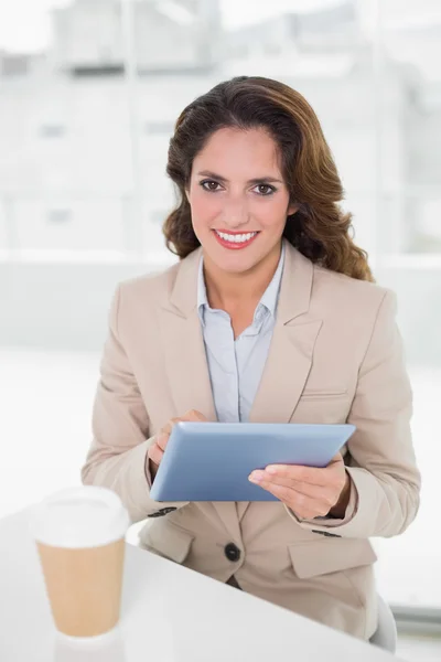 Glad affärskvinna med digital tablet vid hennes skrivbord — Stockfoto