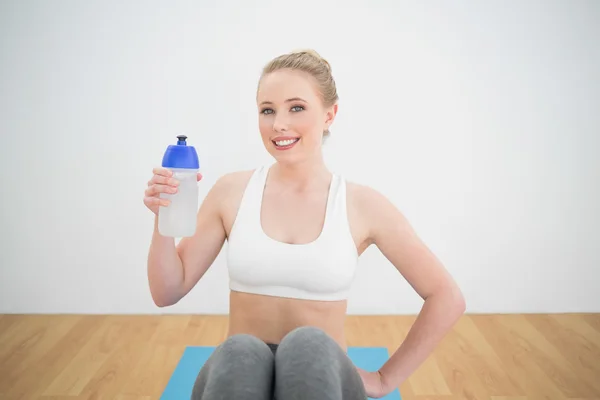 Lächelnde sportliche Blondine mit Wasserflasche — Stockfoto