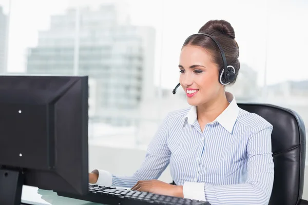 Happy brunette businesswoman using headset — Stock Photo, Image