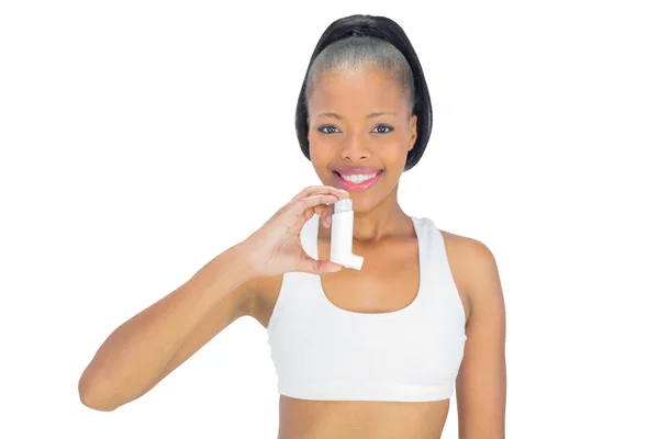 Smiling woman holding asthma inhaler while looking at camera — Stock Photo, Image