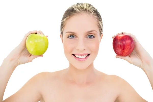 Pleased fresh blonde woman holding two apples Stock Photo
