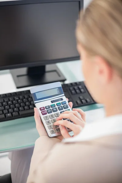 Vista por encima del hombro de la mujer de negocios utilizando la calculadora —  Fotos de Stock