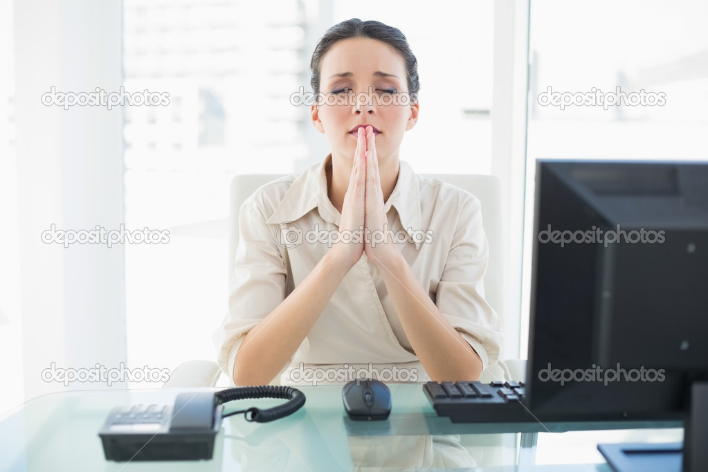 Anxious stylish brunette businesswoman praying