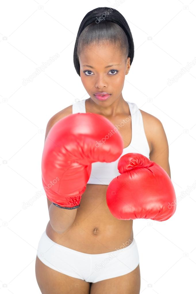 Competitive serious woman wearing red boxing gloves