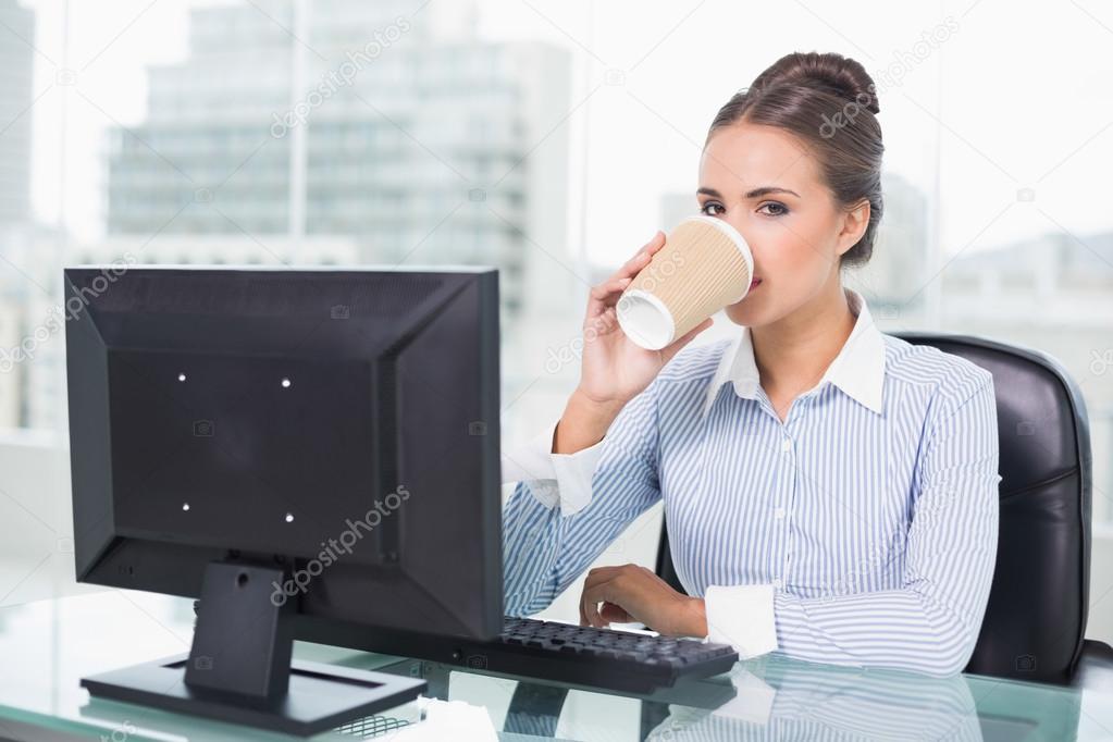 Businesswoman drinking from disposable cup