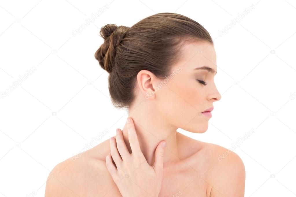 Serious woman closing her eyes and touching her neck