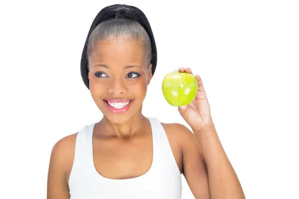 Fröhliche Frau in Sportkleidung hält grünen Apfel in der Hand — Stockfoto