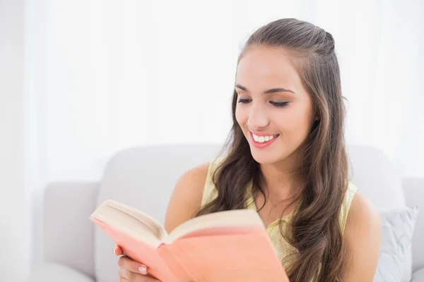 Uśmiechnięta młoda brunetka czytanie książki — Zdjęcie stockowe