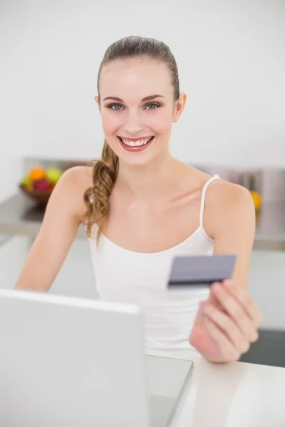 Gelukkig jonge vrouw met behulp van haar laptop voor online winkelen — Stockfoto