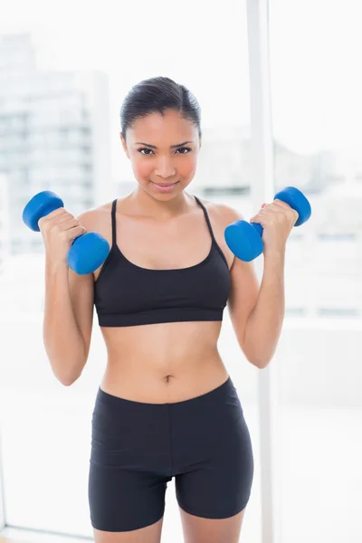 Dynamic model in sportswear exercising with dumbbells — Stock Photo, Image