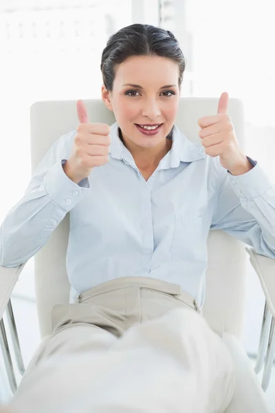 Content stylish brunette businesswoman giving thumbs up — Stock Photo, Image