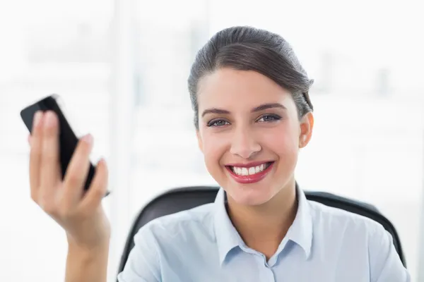 Content businesswoman holding a mobile phone — Stock Photo, Image