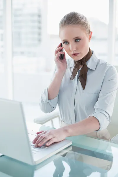 Zakenvrouw met behulp van laptop en bellen — Stockfoto