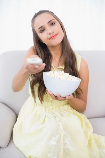 Content young brunette pressing remote — Stock Photo, Image