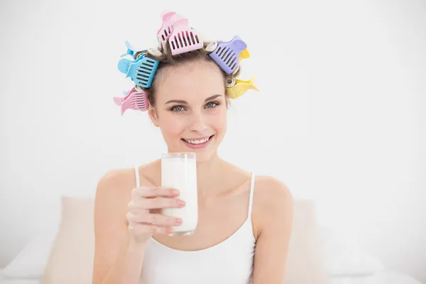 Hermosa mujer en rulos de pelo sosteniendo un vaso de leche — Foto de Stock