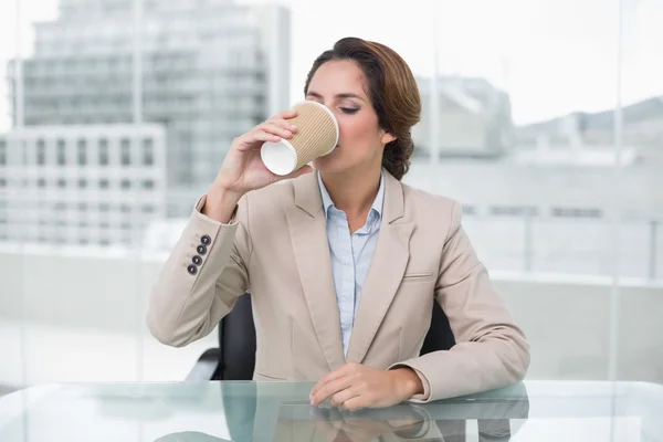 Heureuse femme d'affaires assise à son bureau buvant de la tasse jetable — Photo