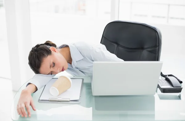 Sleepy elegante morena mujer de negocios acostada en su escritorio —  Fotos de Stock