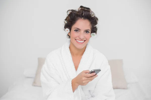 Smiling natural brunette holding smartphone — Stock Photo, Image