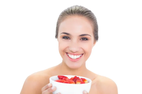 Cheerful young woman holding a bowl of strawberries — Stock Photo, Image