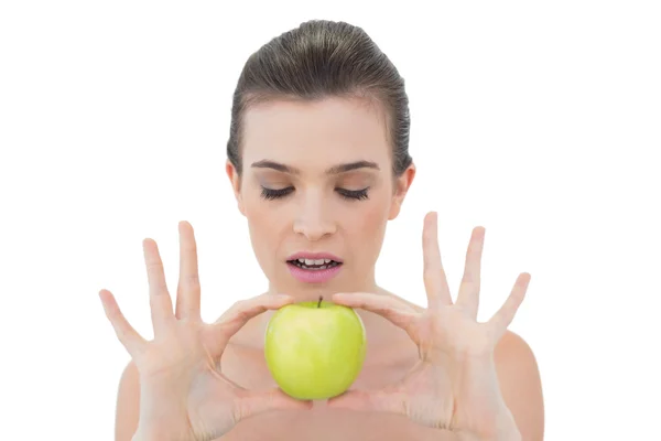 Concentrated model holding a green apple — Stock Photo, Image
