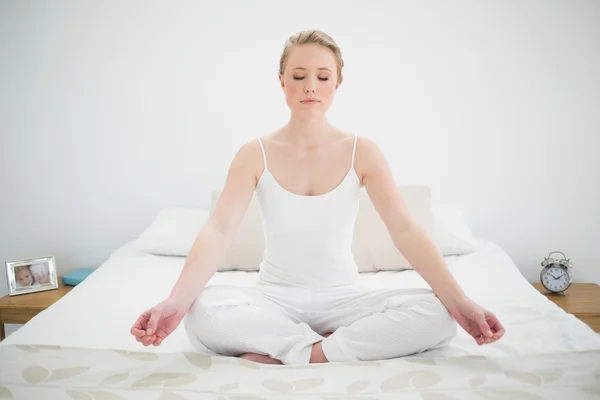 Natural pretty blonde meditating on bed with closed eyes — Stock Photo, Image