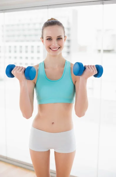 Sportieve vrolijke vrouw bedrijf halters — Stockfoto