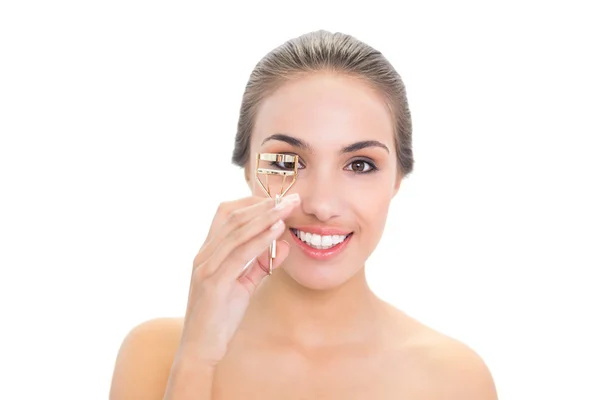 Mujer joven sonriente usando un rizador de pestañas — Foto de Stock