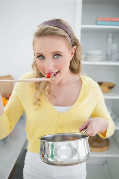 Glimlachend schattige blonde proeverij levensmiddelen uit houten lepel — Stockfoto