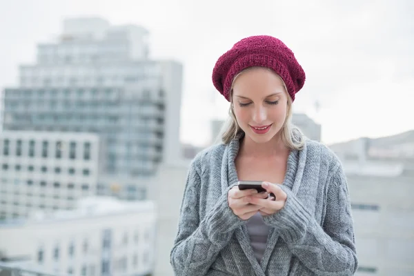 Ler ganska blond textmeddelanden utomhus — Stockfoto