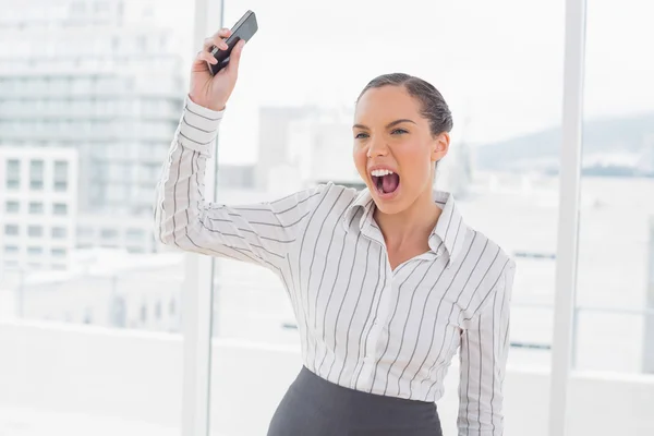 Offended businesswoman screaming and throwing her mobile phone — Stock Photo, Image