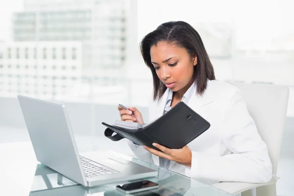 Ansiosa joven empresaria llenando su agenda — Foto de Stock