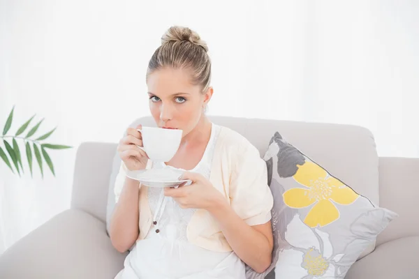 Peaceful fresh model drinking coffee sitting on sofa — Stock Photo, Image