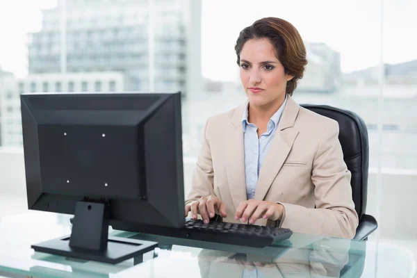 Строгая деловая женщина, сидящая перед компьютером — стоковое фото