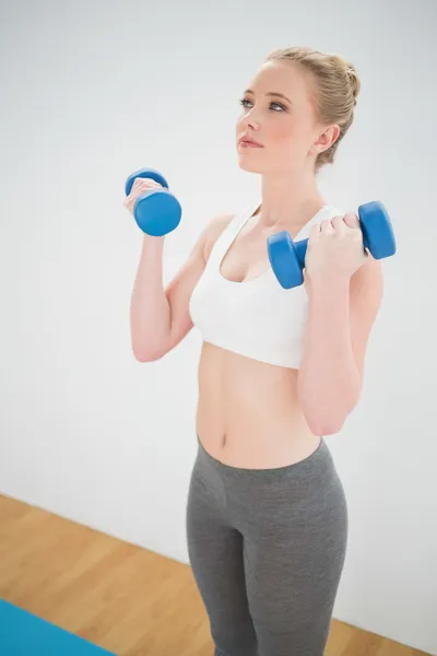 Content sporty blonde holding dumbbells — Stock Photo, Image