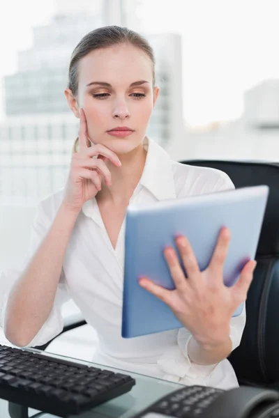 Nachdenkliche Geschäftsfrau sitzt mit Tablet-PC am Schreibtisch — Stockfoto