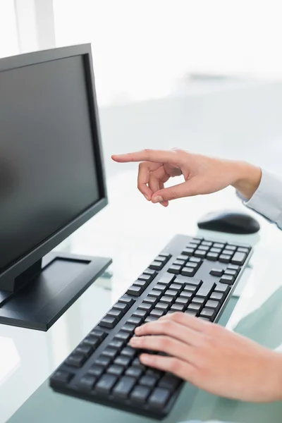 Nahaufnahme einer Geschäftsfrau, die mit dem Finger auf ihren Computerbildschirm zeigt — Stockfoto