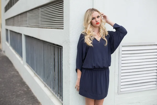 Lächelnde sexy Blondine in edlem Kleid posiert im Freien — Stockfoto