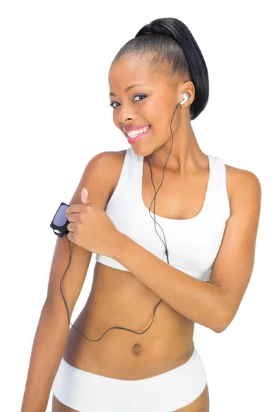 Smiling woman in sportswear using music player while looking at camera — Stock Photo, Image