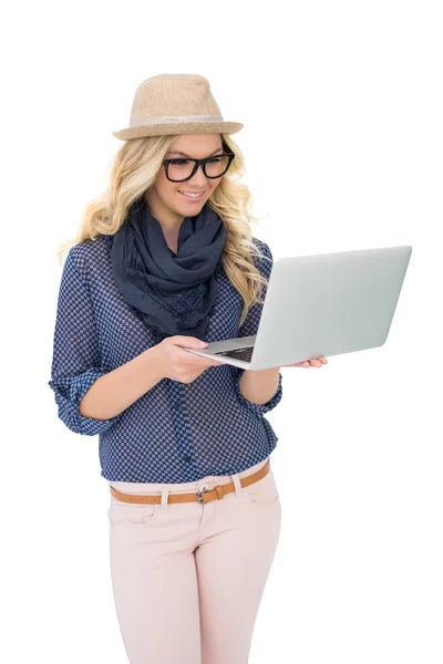 Smiling trendy blonde holding laptop — Stock Photo, Image