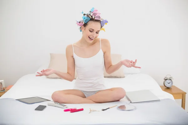 Çekici bir kadın yatağında oturup saç curlers içinde — Stok fotoğraf