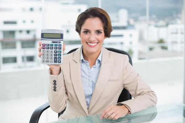 Веселая деловая женщина показывает калькулятор — стоковое фото
