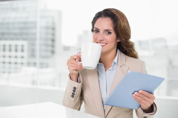 Красивый контент деловая женщина с помощью планшета пить кофе — стоковое фото