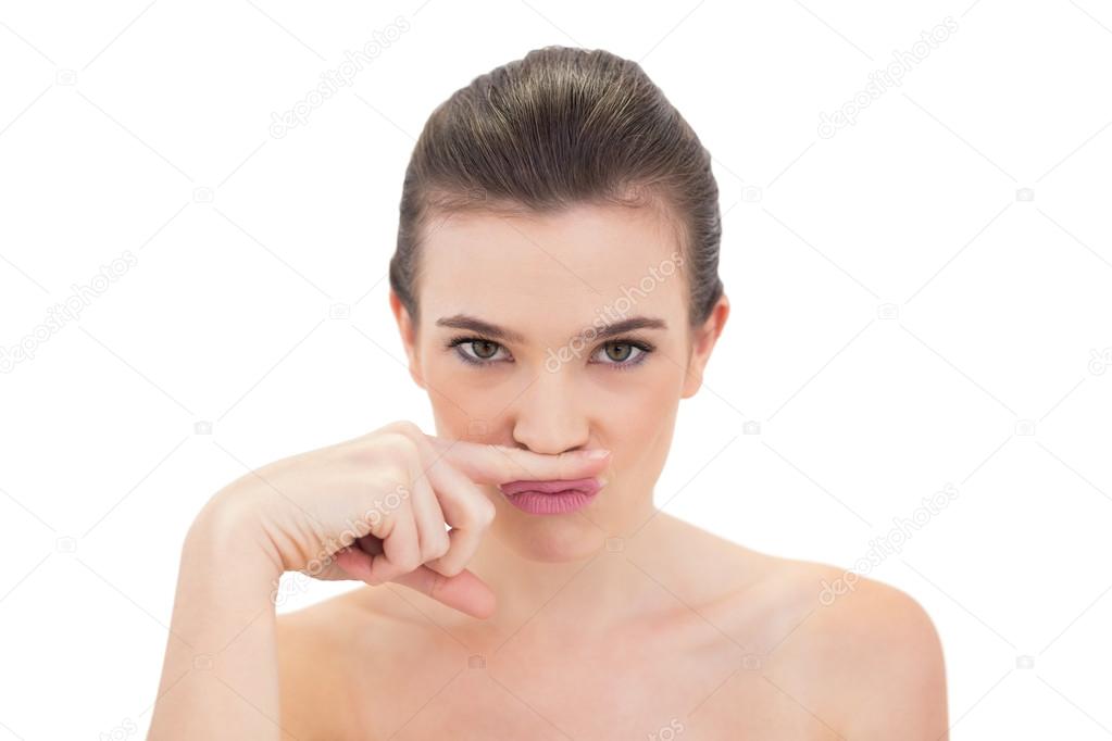 Pouting model putting her finger under her nose