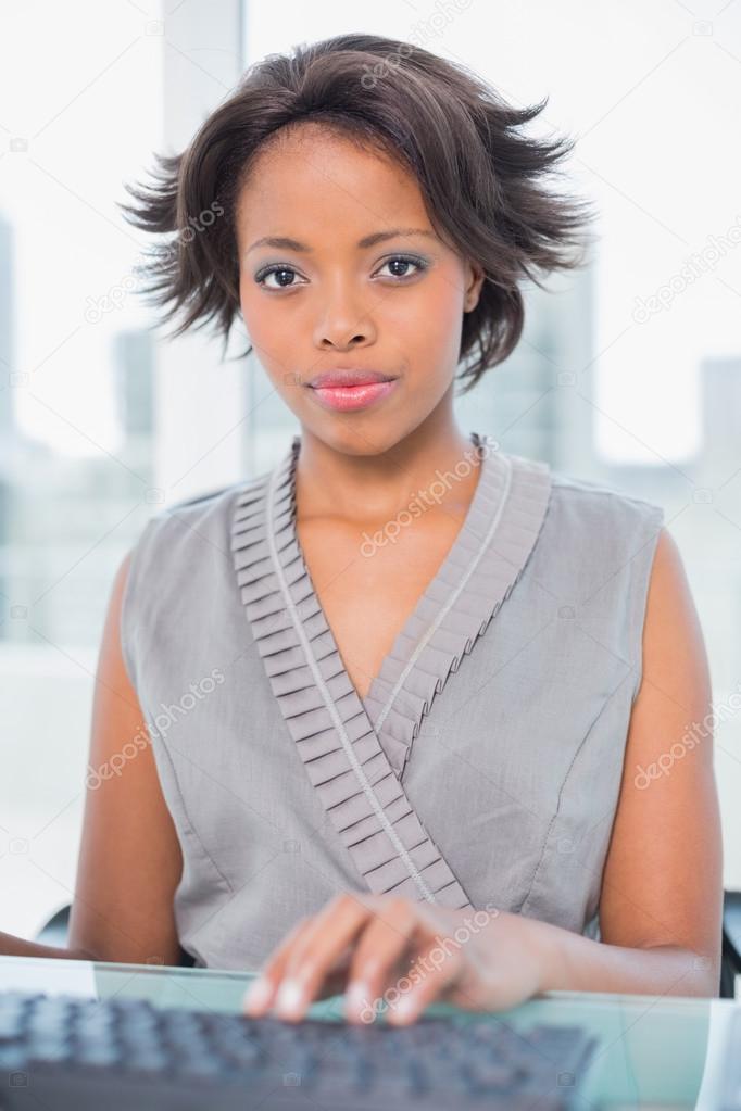 Unsmiling businesswoman working on computer