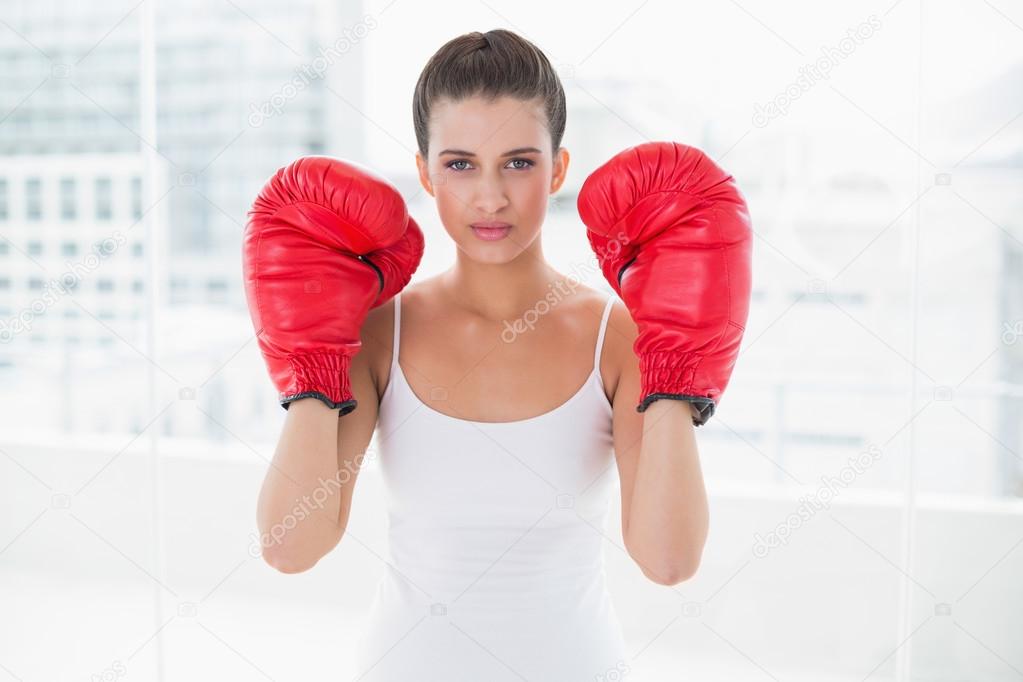 Woman in white sportswear wearing boxing gloves